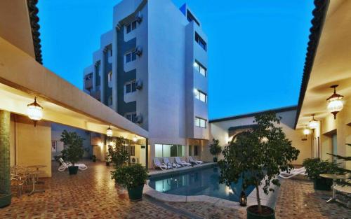 a hotel with a swimming pool and a building at Hotel Splendid in Fez