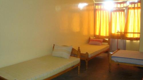 una camera con due letti e una finestra di YMCA Guest house a Batticaloa
