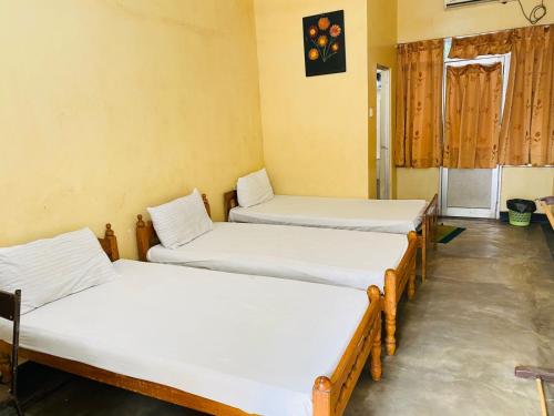 a group of three beds in a room at YMCA Guest house in Batticaloa
