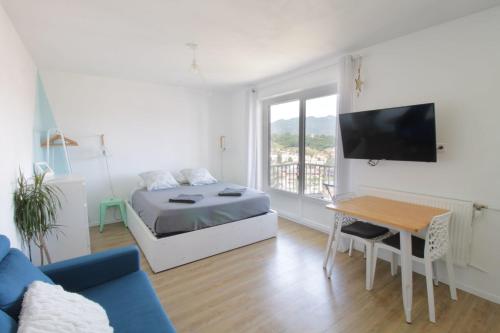 a bedroom with a bed and a desk and a tv at Studio 4 Swimming pool summer parking & superb view! in Aix-les-Bains