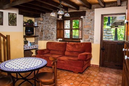 sala de estar con sofá y mesa en La Fragua Castiellu en Bimenes