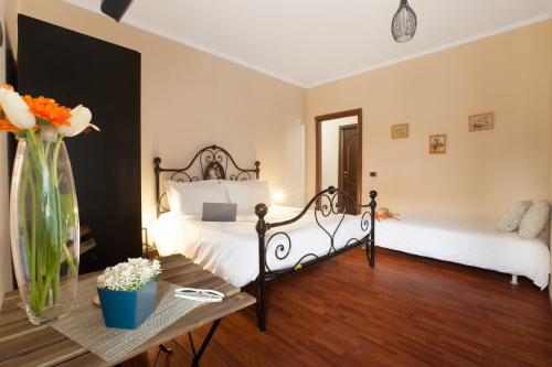 a bedroom with two beds and a table with flowers at BSisters in Torre del Greco
