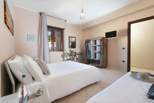 a bedroom with a large white bed and a television at BSisters in Torre del Greco