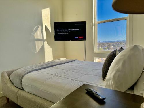a bedroom with a bed with a tv on the wall at Ely on Fremont in Las Vegas