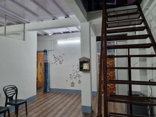 um quarto com uma escada e uma parede com um relógio em Bandhu Lodge em Dibrugarh