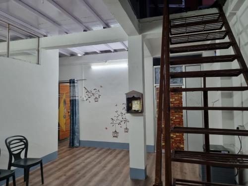 a room with a staircase and a wall with a clock at Bandhu Lodge in Dibrugarh