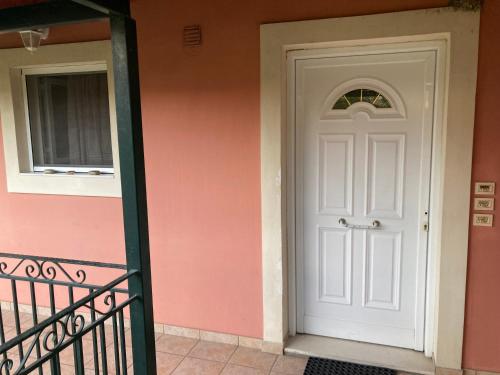 a white door on the side of a house at Διαμέρισμα στην Κέρκυρα in Kanálion