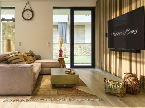 a living room with a couch and a tv at SalvatoreHomes - Pure Luxury in the Centre of Bardolino with Pool & Private Garden - Casa Olivia - a 5 Star Luxury Collection at Lake Garda in Bardolino