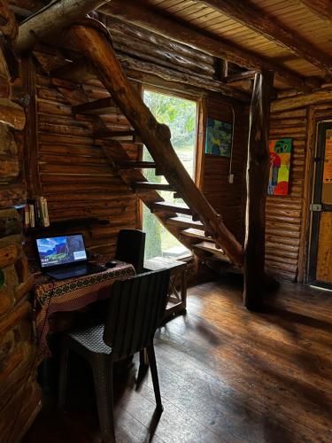 a laptop computer sitting on a desk in a log cabin at La Cabaña Musical in Medellín