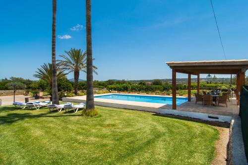 ein Resort mit einem Pool und Palmen in der Unterkunft Villa Darder , Sa garriga in Ariany