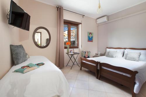 a bedroom with two beds and a mirror at BSisters in Torre del Greco