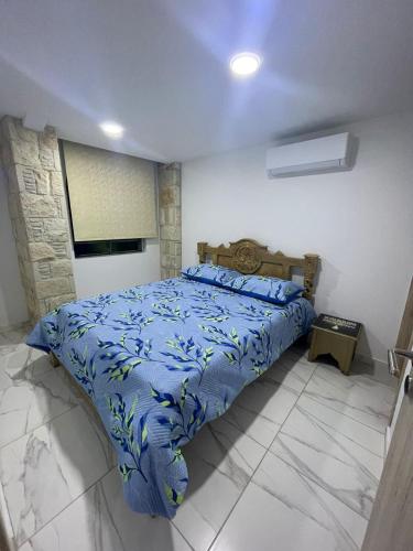 a bedroom with a bed with a blue comforter at La Hacienda Cyprus in Limassol