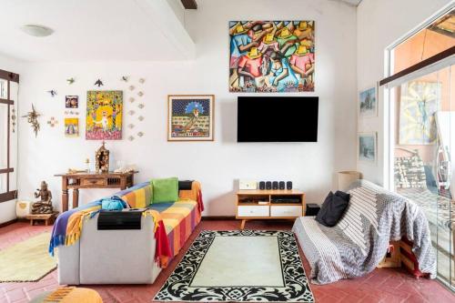a living room with a couch and a tv on the wall at Car in the garage and everything on foot. in Búzios
