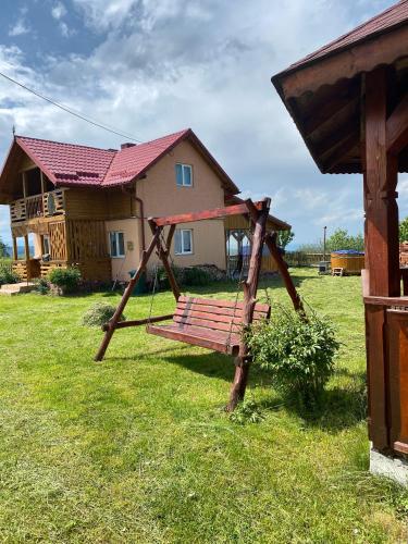 a swing in a yard in front of a house at Ela’s retreat in Dealu Mare