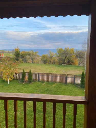 a view of a field from a porch with a fence at Ela’s retreat in Dealu Mare