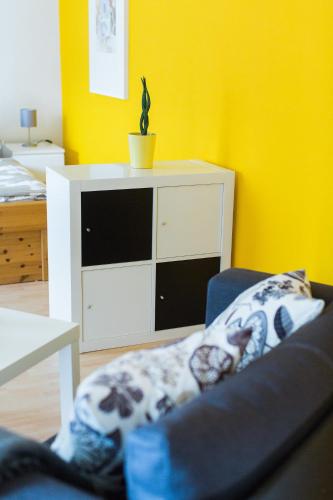 a living room with a couch and a yellow wall at Ferienwohnung Spiegelberg in Spiegelberg