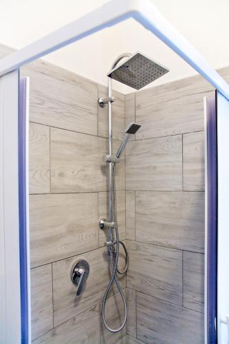 a shower in a bathroom with a wooden wall at vento di mare in Bari