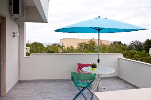 a table and two chairs and an umbrella on a balcony at vento di mare in Bari