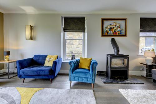 uma sala de estar com duas cadeiras azuis e um fogão em The Farm House em Richmond