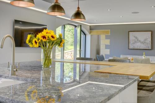 a kitchen with a counter with a vase of sunflowers at The Gate House in Richmond