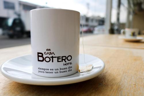 a white coffee cup sitting on top of a table at Hotel Casa Botero 101 in Bogotá