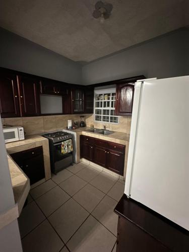 a kitchen with a white refrigerator and a stove at Hospedaje en Juticalpa in Juticalpa