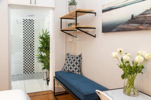 a living room with a blue couch and a staircase at Loddey`s Guest House - by Beach Collection in Strand