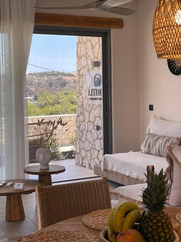 a living room with a table with bananas and a window at Lithos Luxury Villa in Archangelos