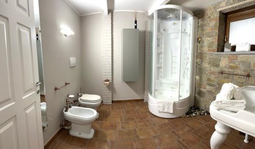 ein Badezimmer mit 2 WCs, einer Dusche und einem Waschbecken in der Unterkunft Appartamento Ebhouse in Capiago Intimiano