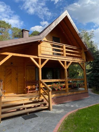 duży drewniany dom z gankiem i kwiatami w obiekcie Bajkowa Przystań domki nad jeziorem 