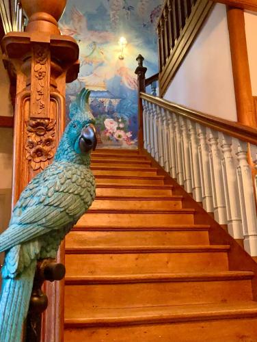 a statue of a peacock on the side of a staircase at La Villa des Roses Gîte Chambres d'hôtes Piscine chauffée in Luçon