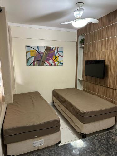 a room with two beds and a flat screen tv at Lacqua Diroma 1 2 3 4 5 in Caldas Novas