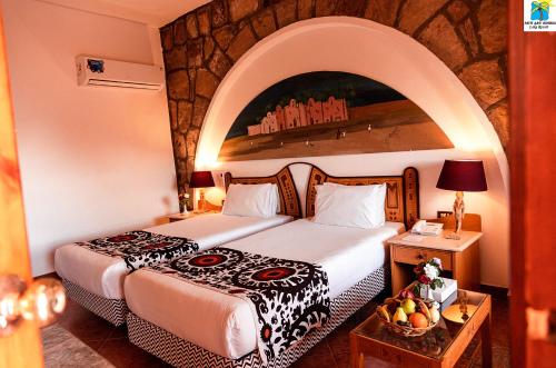 a hotel room with two beds and a table at Seti Abu Simbel Lake Resort in Abu Simbel