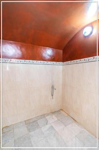 a bathroom with a tile floor and a ceiling at Zine Villa Guest House in Marrakech