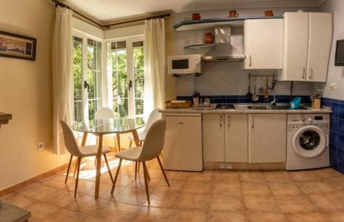 a kitchen with a table and a table and chairs at Casitas Del Huerto in La Alberca
