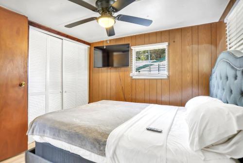 Ocala Farm Lake House في Ocklawaha: غرفة نوم بسرير ومروحة سقف
