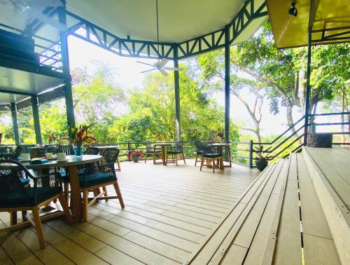 a wooden deck with tables and chairs on it at Villas en el Bosque in Ojochal