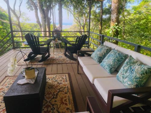a living room with a couch and chairs on a deck at Villas en el Bosque in Ojochal