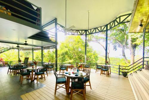 a restaurant with tables and chairs on a deck at Villas en el Bosque in Ojochal