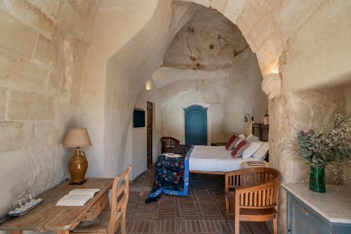 una camera con letto e tavolo di Locanda Di San Martino Hotel & Thermae Romanae a Matera