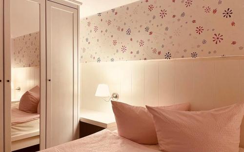 ein Schlafzimmer mit einem Bett mit einer Wand mit Blumen in der Unterkunft Ferienhaus Lisa am Silbersee in Frielendorf