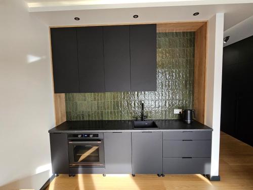 a kitchen with a sink and a stove at Apartament Hańcza in Suwałki