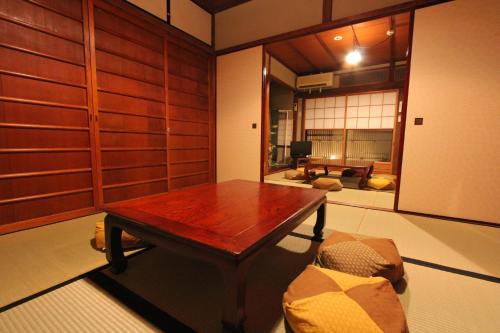 a room with a wooden table and a couch at Our-Turn Traditional Machiya near Heian Shrine in Kyoto