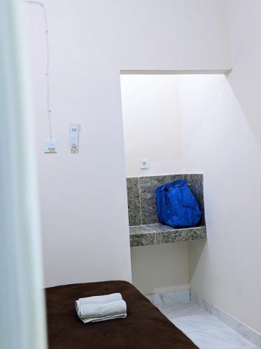 una camera con un letto con una borsa blu di Bunda House Syariah Lapai a Padang