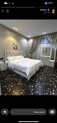 ein Schlafzimmer mit einem großen weißen Bett in einem Zimmer in der Unterkunft شقة مفروشة راقية in Al Ḩawīyah