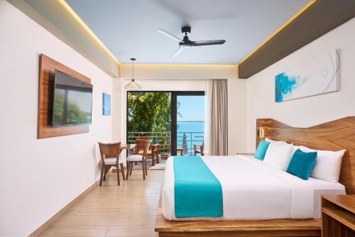 a bedroom with a bed and a balcony at Cristalino Lagoon Front Hotel, Restaurant & Spa in Bacalar