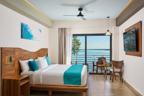 a bedroom with a bed and a view of the ocean at Cristalino Lagoon Front Hotel, Restaurant & Spa in Bacalar