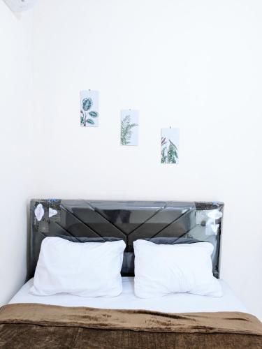 巴東的住宿－Bunda House Syariah Lapai，一张带黑色床头板和白色枕头的床