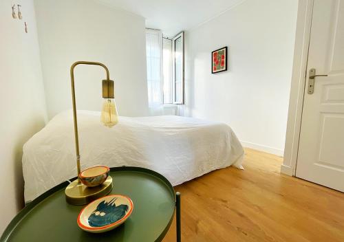 a green table with a bowl on it next to a bed at Charmant appartement rénové au cœur de Concarneau in Concarneau