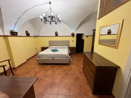 una camera con letto, tavolo e lampadario a braccio di La casa di Mimmo a Foggia